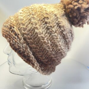 Gebreide beige muts met bijzonder patroon met grote pompom